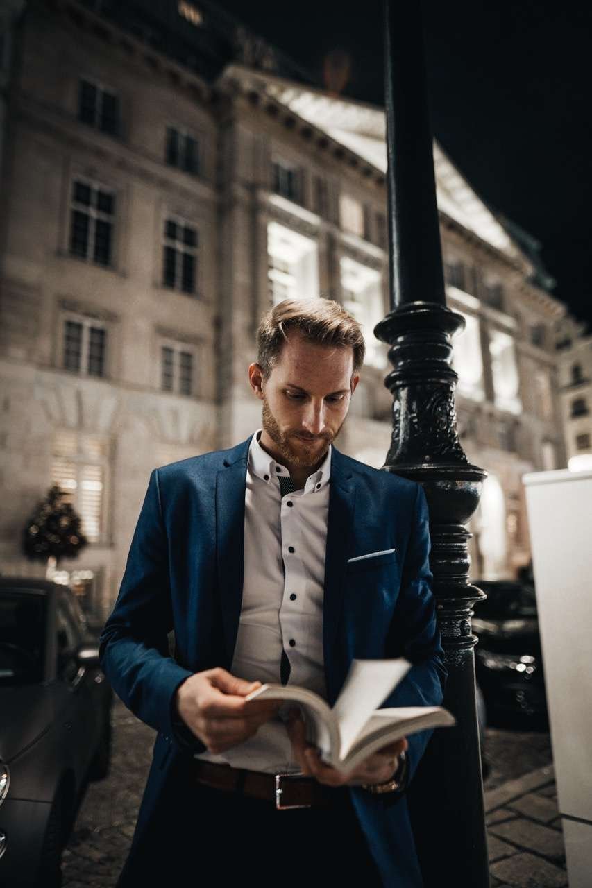 Martin&Klein, Lukas Rother, Finanzberater und Gründer von MoneyMentor, blättert durch ein Buch